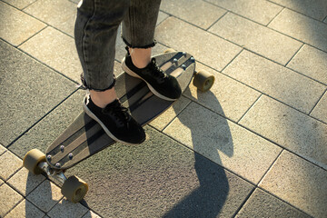 Girl rides skateboard. Teenager rides on board. Details of walk in square.