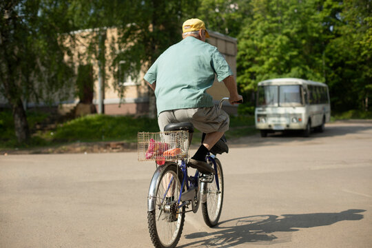 Elderly man on bicycle. Old man rides bicycle. Man in town.