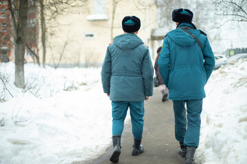 Two guys in uniform. Men come from service in Russia. People in warm clothes in Siberia. Blue shape.