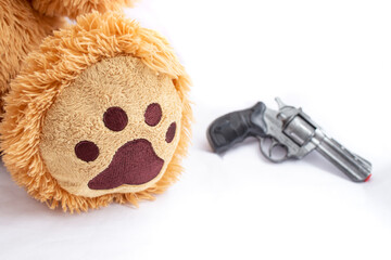 Teddy bearfoot pattern with a toy handgun blurred in the background, school violence concept