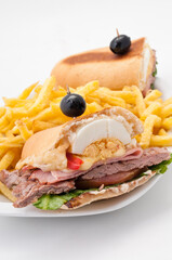 Chivito al pan. El chivito es un sándwich de carne vacuna y otros ingredientes, generalmente aderezado con mayonesa y acompañado de papas fritas, algunas veces con ensalada rusa