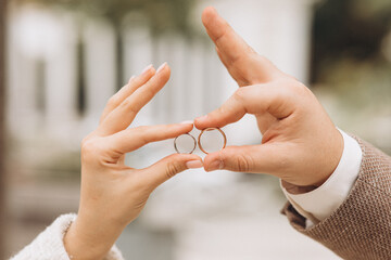 Newlyweds exchange rings, groom puts the ring on the bride's hand.