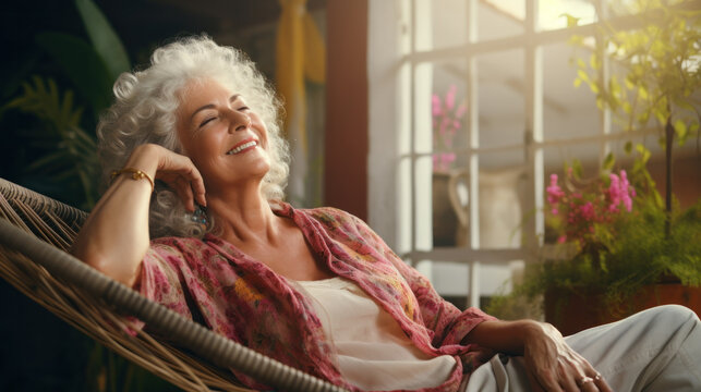 Home lifestyle mature woman relaxing sleeping on sofa on outdoor patio living room. Happy lady lying down on comfortable pillows taking a nap for wellness and health. Tropical vacation. - Powered by Adobe