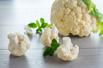 slices of raw small raw cauliflower on wooden table