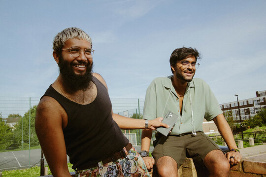 Two young multiracial men having fun in street style clothes