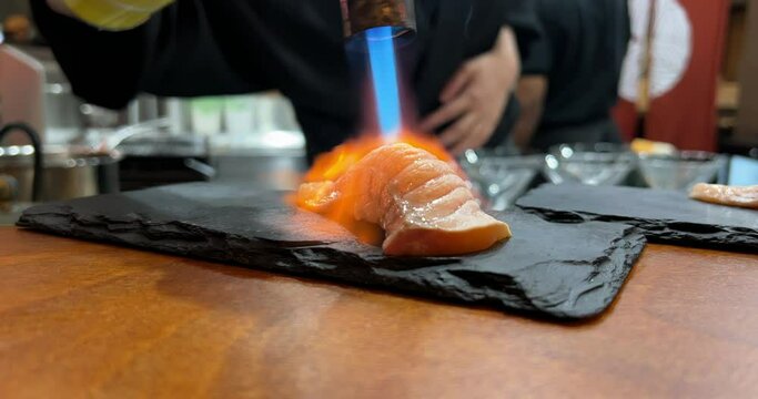 Authentic Japanese Salmon Aburi sushi is prepared by an expert chef. Shot in 4k