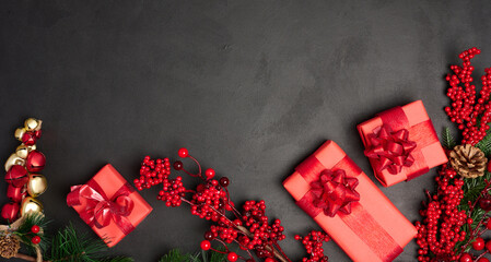 Christmas decor and gifts wrapped in red paper on a black background, top view