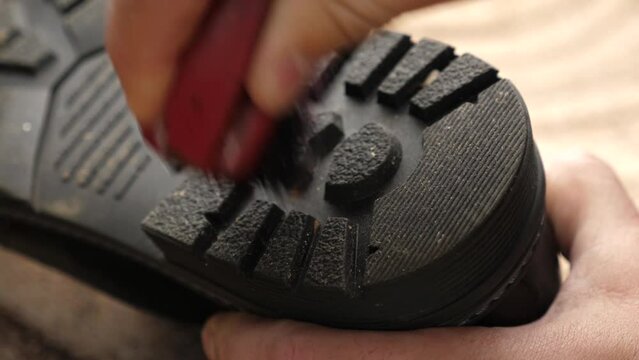 The soles of the shoes are cleaned with a brush. The concept of shoe care.