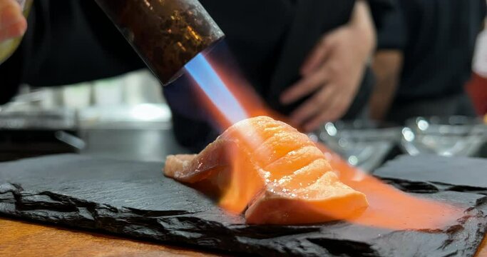 Authentic Japanese Salmon Aburi sushi is prepared by an expert chef. Shot in 4k