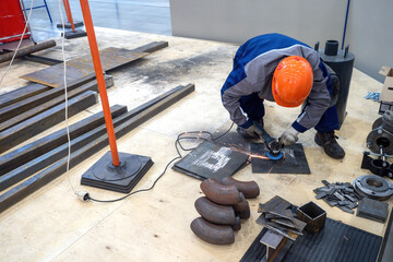 Man builder. Production employee inside workshop. Construction worker uses grinding machine. Man...