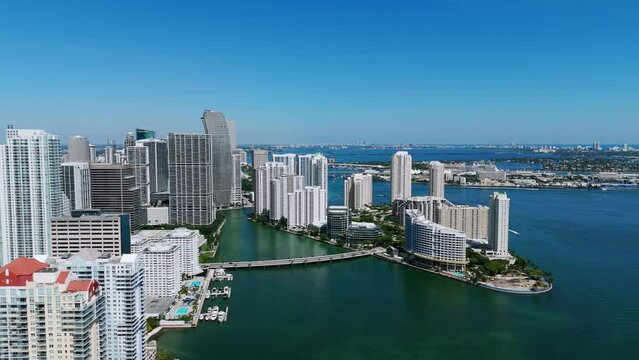 Breathtaking aerial view of downtown buildings located in Miami with port on background. Road bridge between magnificent multi-storey buildings under bright sky. Brickell Key