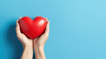 Fototapeta premium Love and Care: Hands Embracing a Red Heart on a Serene Blue Background