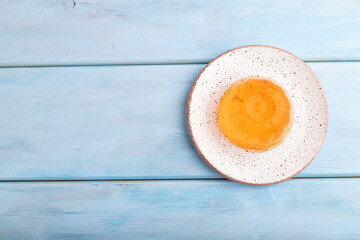 Apricot orange jelly on blue. top view, copy space.