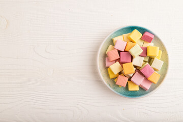 Various fruit jelly chewing candies on white wooden. apple, banana, tangerine, top view, copy space.