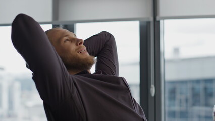 Relaxed creator taking break at office closeup. Man putting hands behind head
