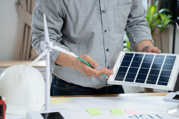 Businessmen with solar panel on desk in office.