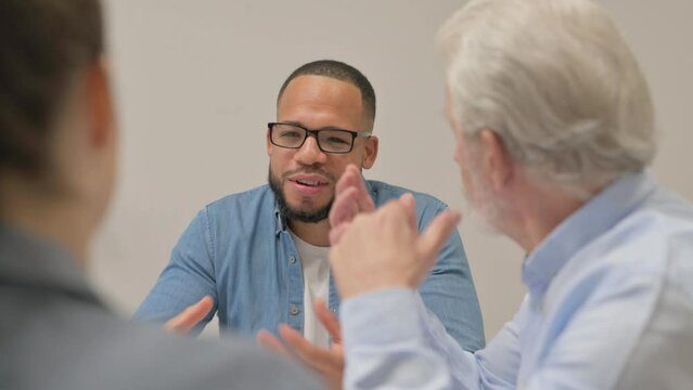 Hispanic Man Discussing Business with Teammates