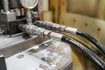 Hydraulic hoses with pressure sensor for oil flow.