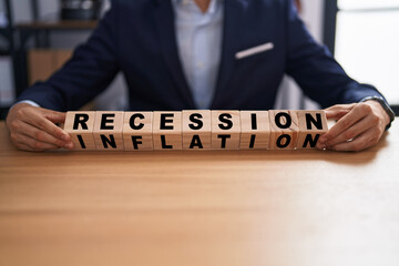 Business man holding cubes with recession and inflation words on the table