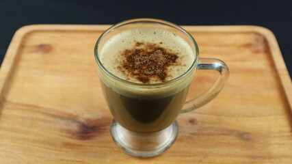 Hot Cappuccino coffee on wooden tray. dark background, top view