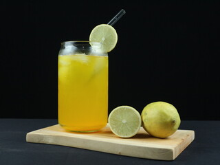 Cool freshly made lemonade and fruits on wooden tray . dark background. side view, close-up view.