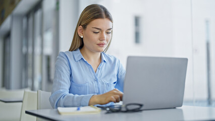 Young blonde woman business worker using laptop working at office