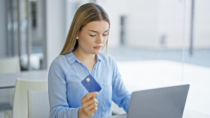 Young blonde woman business worker using laptop and credit card at office