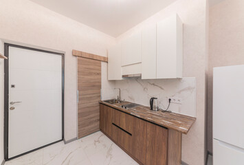 Kitchen wall in studio apartment, stove and drawers for dishes