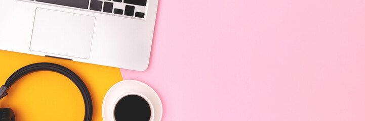 Banner with headphones, cup of black coffee and laptop on a yellow and pink background. Business concept. - obrazy, fototapety, plakaty