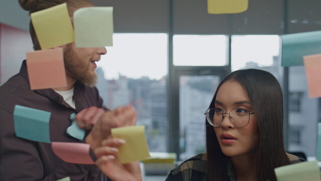 Angry man tearing sticker at office closeup. Team arguing at strategy board room - Powered by Adobe