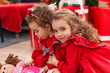 Adorable girls hugging each other celebrating christmas at home