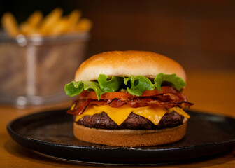 Hamburguer de carne com queijo e bacon com salada de alface e tomate