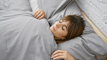 Cozy morning slumber, a beautiful young hispanic woman resting comfortably, lying in bed, sleeping...
