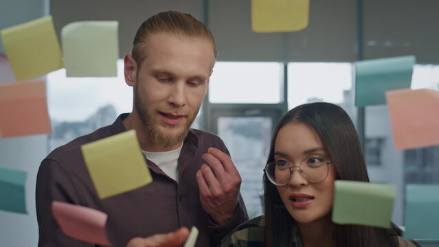 Nervous team arguing at stickers wall office closeup. Angry man tearing notes - Powered by Adobe