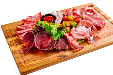 Variety of meats, sausages, salami, ham, olives, laid out on a wooden board