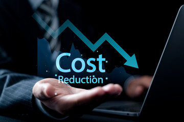 Cost reduction Concept. Businessman use laptop and holding graph with down arrow icon for budget...