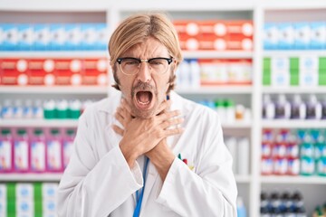 Caucasian man with mustache working at pharmacy drugstore shouting and suffocate because painful strangle. health problem. asphyxiate and suicide concept.