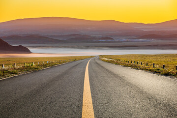 Asphalt highway road and mountain natural landscape at sunrise