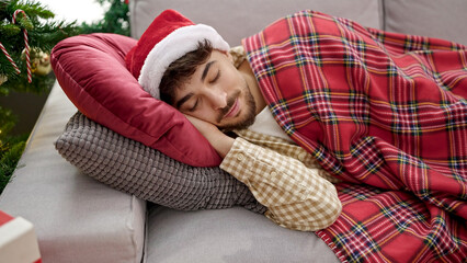 Young arab man sleeping on the sofa at christmas at home