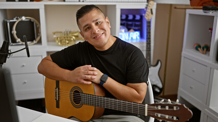 Handsome young latin man, a confident musician, holding his classic guitar and smiling radiantly in...