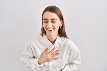 Young caucasian woman standing over isolated background smiling and laughing hard out loud because funny crazy joke with hands on body.