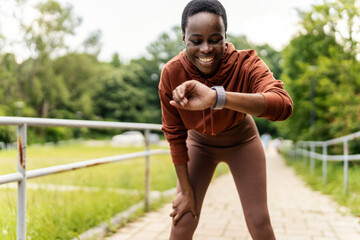 Black woman runner, smartwatch and rest for breathing, heart rate or health while training in...