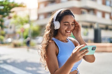 Young beautiful hispanic woman smiling confident watching video on smartphone at street