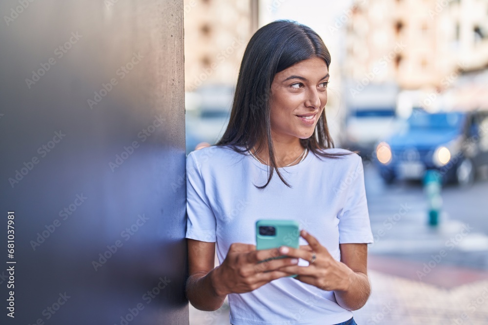 Canvas Prints Young beautiful hispanic woman smiling confident using smartphone at street