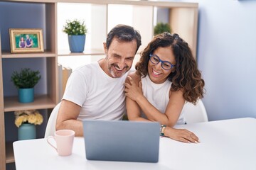 Man and woman couple smiling confident using laptop at home