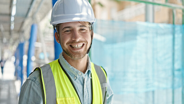 Young caucasian man architect smiling confident standing at construction place