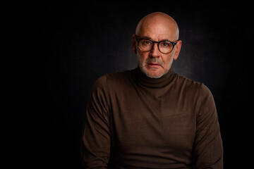 MId aged bald man wearing turtleneck sweater and glasses against isolated background