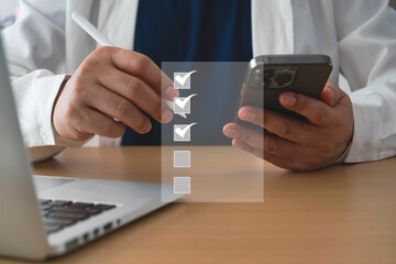 Businessman using pen to tick correct sign mark on checklist for quality control assurance of ISO concept. Business performance checklist,Quick checklist and clipboard management concept. checklis.