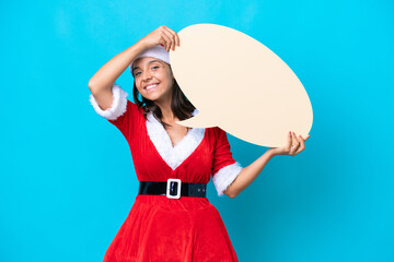 Young hispanic woman dressed as mama noel isolated on blue background holding an empty speech bubble
