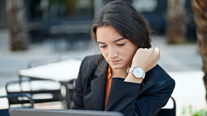 Young beautiful hispanic woman business worker using laptop with relaxed expression at coffee shop terrace